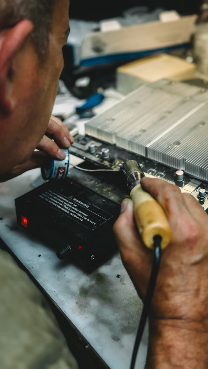 Technician using soldering iron on a circuit board, showcasing precision work in electronics repair.